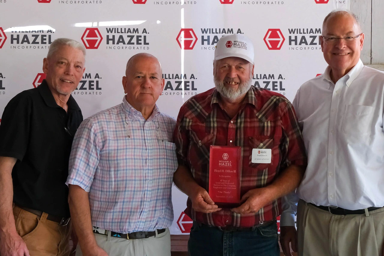 Floyd Dillon III smiling and accepting his 40 Years of Service award from William A. Hazel executives on a sunny day